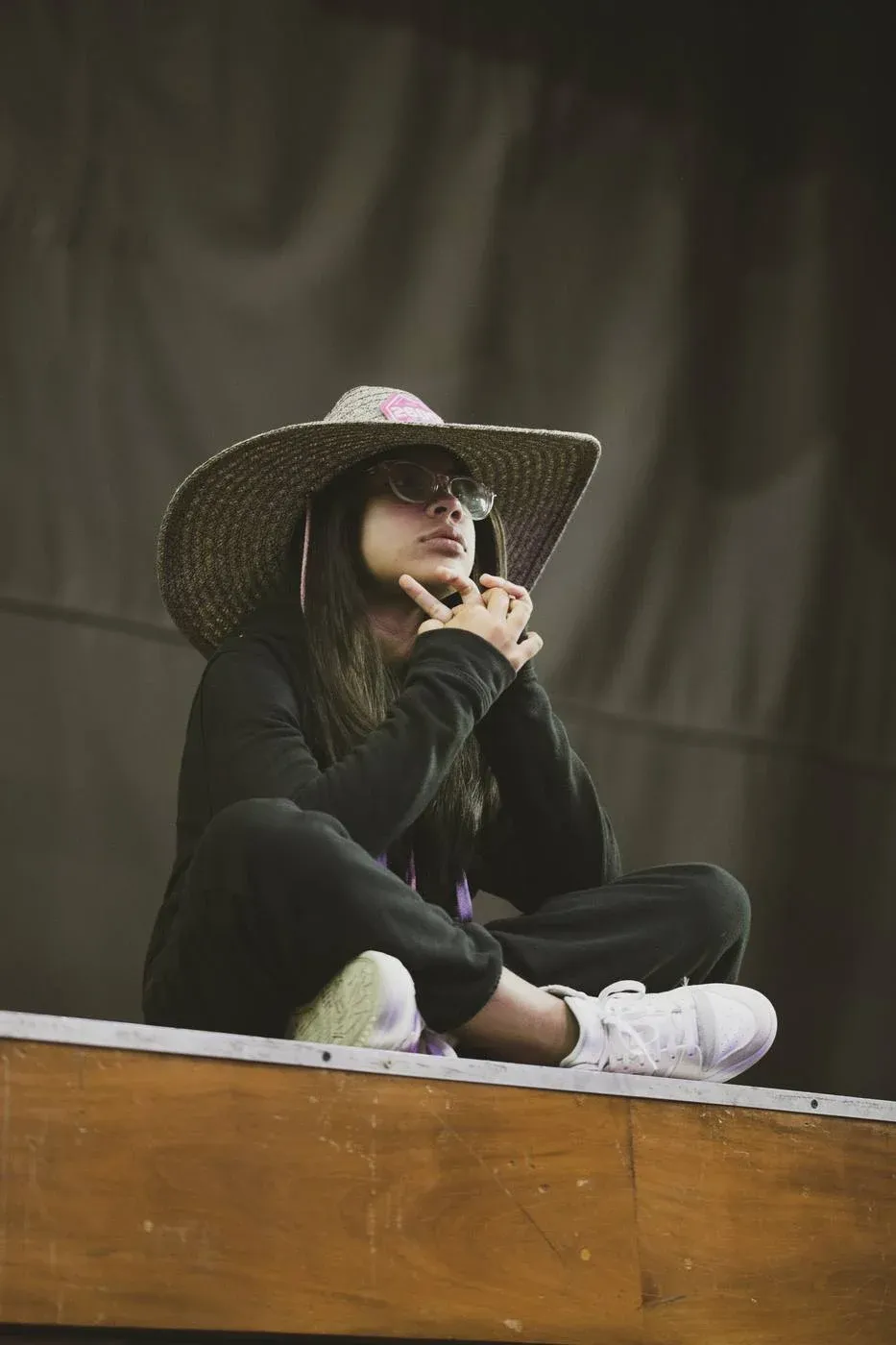 Joven asistente del festival observando el evento desde una tarima